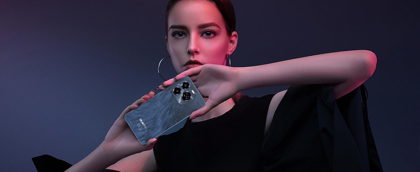 Carta di credito grigia tenuta tra le dita su sfondo scuro. La carta presenta motivi geometrici e un chip visibile.